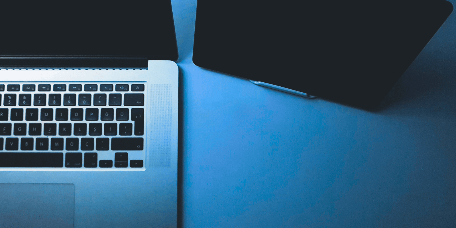 Optimize podcast for search engines blog image: A close-up of a desk with part of a laptop and tablet visible.